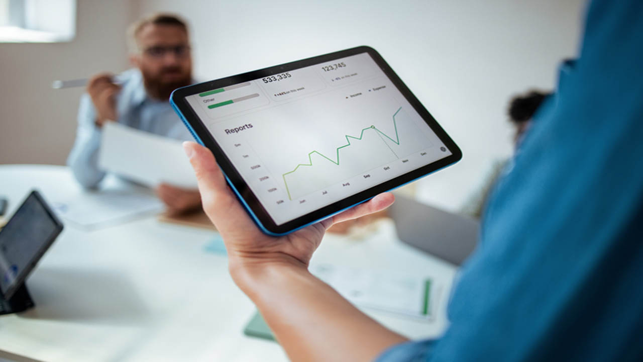 Fuel Supplier Business Team Meeting Analyzing Financial Reports on Tablet
